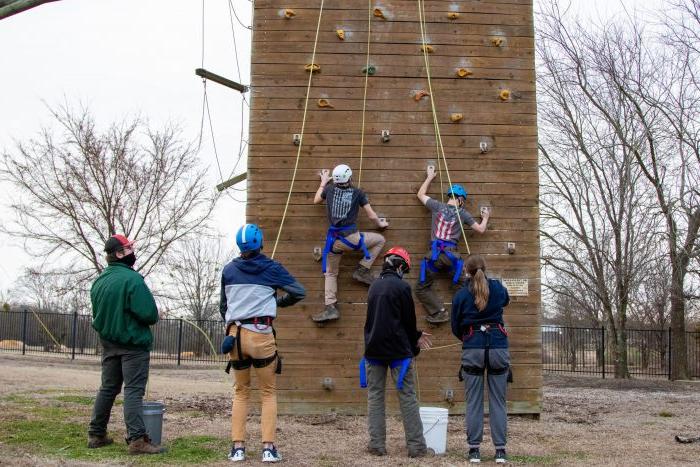 A group of students climbing a rock wall.